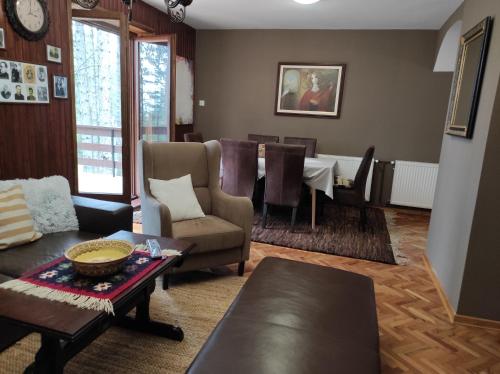 a living room with a table and a dining room at Vila Vera in Zlatibor