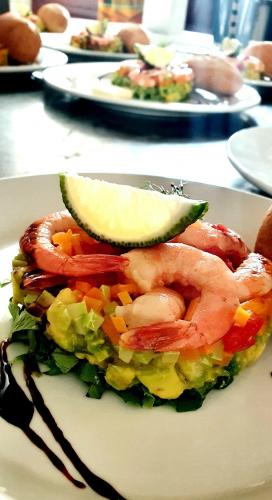 a plate of food with shrimp and vegetables on a table at L'Address in Cotonou