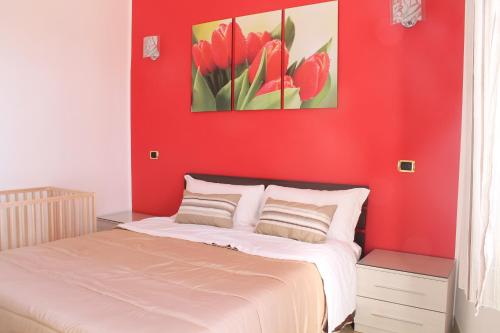 a bedroom with a red wall and a bed at B&B Vesuvio Smiling in Ercolano