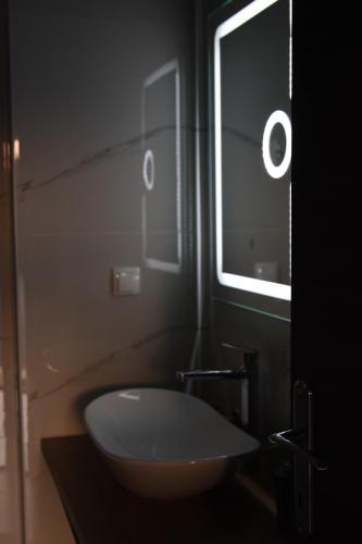 ein Bad mit einem weißen Waschbecken und einem Fenster in der Unterkunft Kuća za odmor Maja in Ðakovo