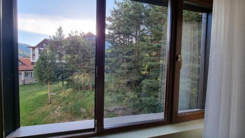 a window with a view of a yard at Borovets Hills Apartments - Studio 33 in Borovets