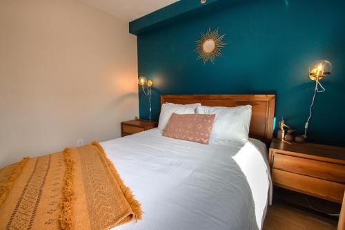 a bedroom with a white bed with a blue wall at BOHEMIAN - SelfCheckIn - Rooftop - Terraces - St-Denis in Montréal