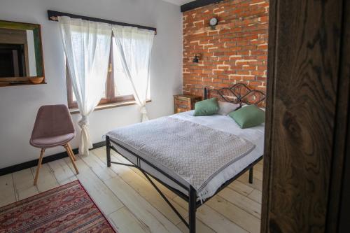 1 dormitorio con cama y pared de ladrillo en ANTICA RESIDENZA TOSCANA, en Dumbrăviţa