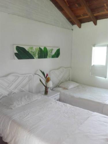 プエブロ・タパオにあるFinca Hotel El Piñal en Armenia Quindioの白いベッドルーム(ベッド2台、窓付)