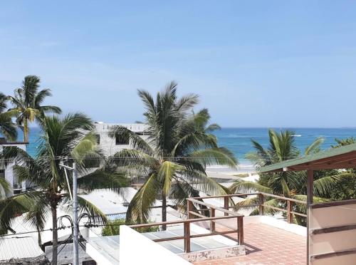 uma vista para a praia a partir da varanda de um resort em Sun Island em Puerto Villamil
