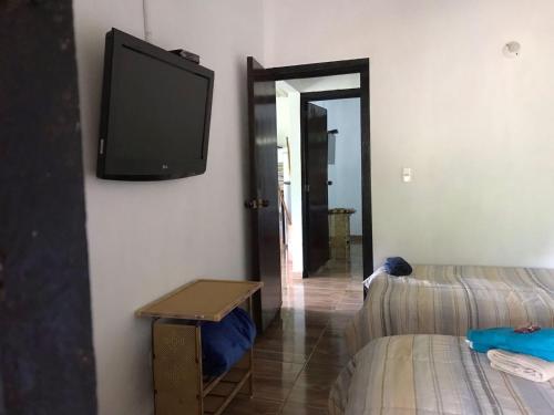 sala de estar con TV de pantalla plana en la pared en Casa en la Montaña en Macanal