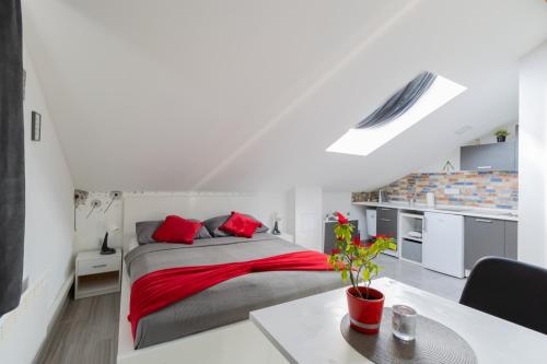 1 dormitorio con 1 cama con almohadas rojas en Hill apartman - MAKSIMIR Rebro, en Zagreb