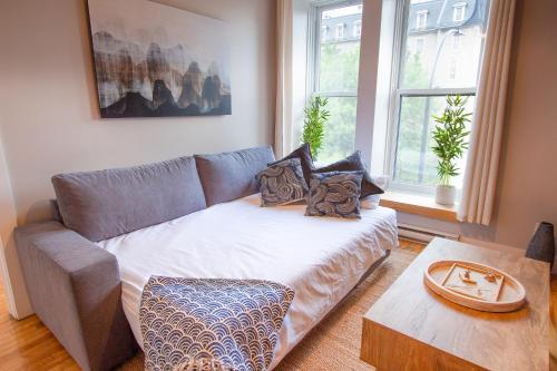 a living room with a couch and a table at ZEN - SelfCheckIn - Rooftop - Terraces - St-Denis in Montréal