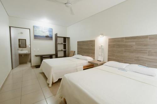 Habitación de hotel con 2 camas y escritorio en Hotel Guivá San Pablo, en Hacienda Blanca