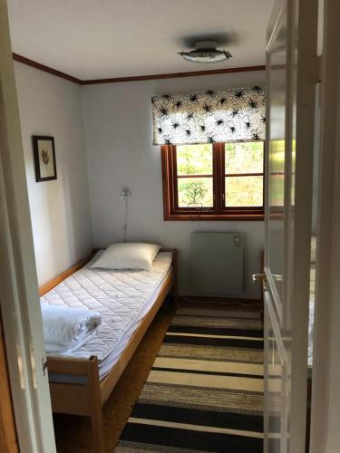 een kleine slaapkamer met een bed en een raam bij Sävekulla 208 "Lillekulla" in Sävekulla