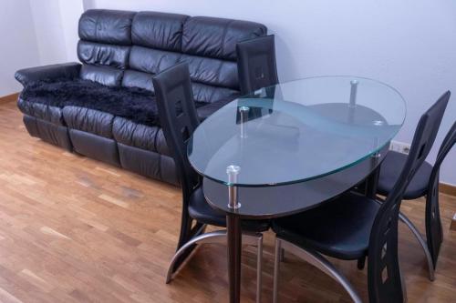 LA ESTANCIA DE PIZARRO في خيخون: طاولة وكراسي زجاجية في غرفة معيشة مع أريكة