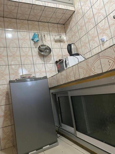 a kitchen with a counter and a refrigerator at RÉSIDENCE MARTHA in Yaoundé