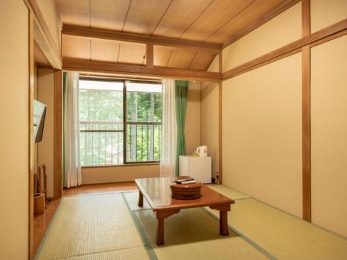 a living room with a table and a window at Yamanaka Lake ＲＹＯＺＡＮ - Vacation STAY 32152v in Yamanakako