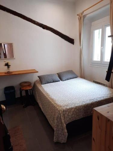 une chambre avec un lit avec des oreillers bleus et une fenêtre dans l'établissement Studette en plein cœur du Vieux Nice, à Nice