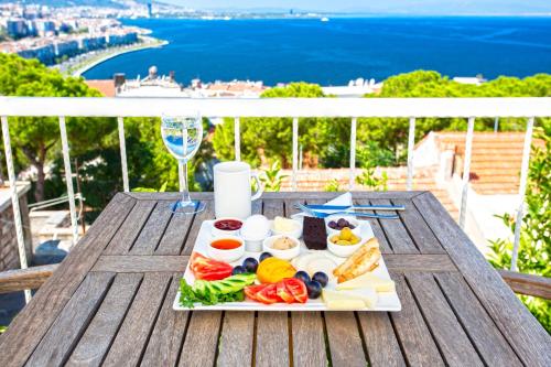 a plate of food on a table with a glass of wine at Iconic Stone Houses in İzmir