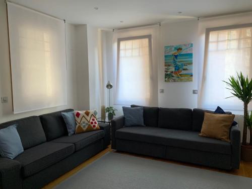 a living room with two couches and two windows at TARASKA BARRIA. Céntrico y coqueto en zona tranquila in Bermeo
