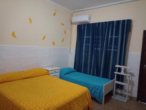 a bedroom with two beds and a blue curtain at Filipo Departamento in Paso de los Libres