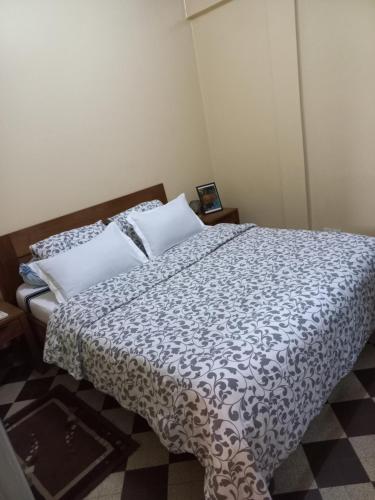 a bedroom with a bed with a black and white comforter at Appartement sympathique Jules Ferry. in Dakar