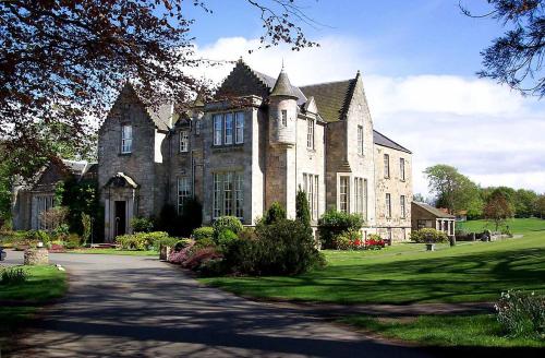 a large stone house with a driveway in front of it at Kilconquhar Castle Estate in Kilconquhar