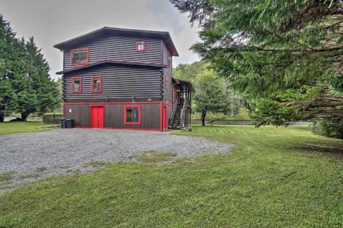 a large barn with a red door in a yard at Rivers Edge - Ultimate Riverfront Getaway in Hayesville