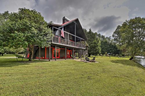 a large house with red doors on a grass field at Rivers Edge - Ultimate Riverfront Getaway in Hayesville