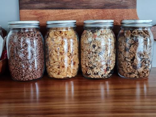 a group of four jars of granola on a table at Okauia House, Matamata in Matamata