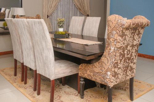 a dining room with a table and two chairs at Senaville Guesthouse in Louis Trichardt