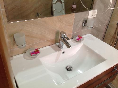 a white sink in a bathroom with a mirror at Hotel Green in Tirana