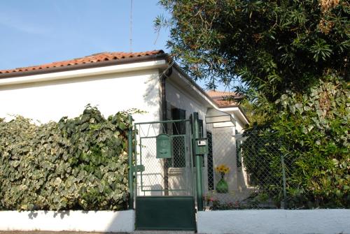 a white building with a green gate and a hedge at Da Irene in Mestre