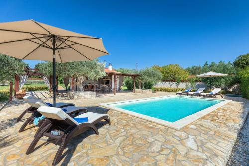 einen Pool mit Stühlen, einem Sonnenschirm und einem Pool in der Unterkunft Casa La Vida in Galižana