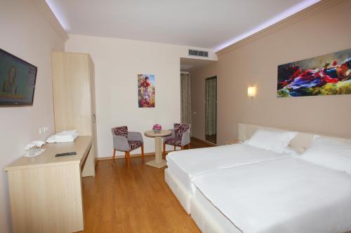 a hotel room with a bed and a table at Hotel Green in Tirana