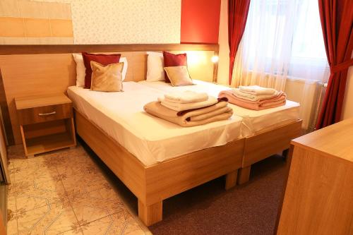 1 dormitorio con 1 cama con toallas en Hotel North City, en Kosovska Mitrovica