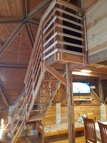 a wooden staircase in a room with chairs at בקתת עץ בחורש במנות - דום גיאודזי - Wooden cabin in Manot in Manot