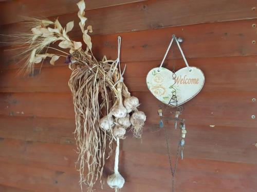 un signo en forma de corazón colgado en una pared con plantas secas en בקתת עץ בחורש במנות - דום גיאודזי - Wooden cabin in Manot en Manot