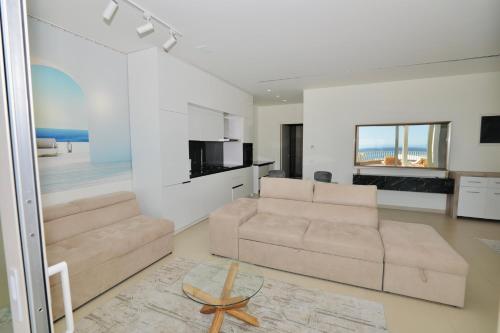 a living room with a couch and a table at Green Coast Resort & Residences 94 in Palasë