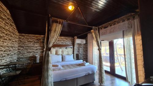 a bedroom with a bed and a brick wall at Mavisu Deluxe Butik Otel in Trabzon