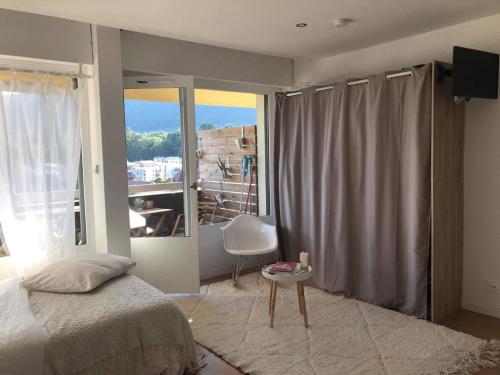 a bedroom with a bed and a large window at HeberGeneve : Balcon sur le Jura in Gex