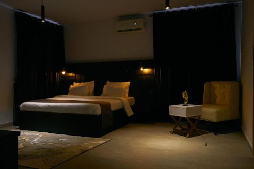 1 dormitorio con cama, silla y luces en The Bermondsey apartments, en Lagos