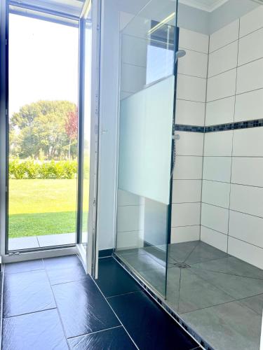 a shower with a glass door in a bathroom at Ferienhaus Malte Büsch in Barlt