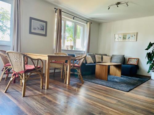 sala de estar con mesa, sillas y sofá en Ferienhaus in Dithmarschen, en Barlt
