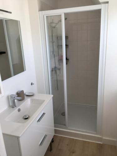 een witte badkamer met een douche en een wastafel bij Nouveau! Superbe appartement avec terrasse vue mer in Ambleteuse