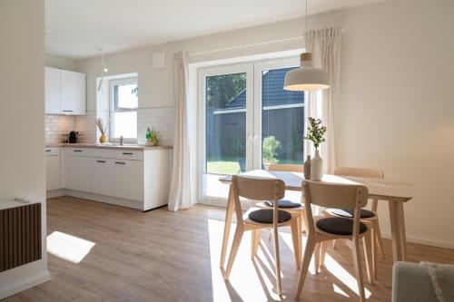 a kitchen and dining room with a table and chairs at Moderne Ferienwohnung in Nordseenähe (Butze #2) in Mildstedt
