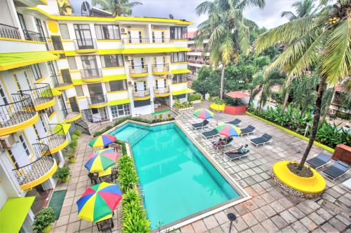 een uitzicht over het zwembad van een hotel met parasols bij Santa Monica Resort - Calangute in Calangute