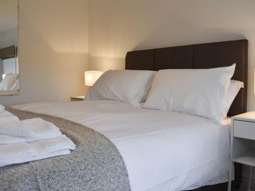 a bed with white sheets and pillows in a room at Thistle Cottage in Carlton