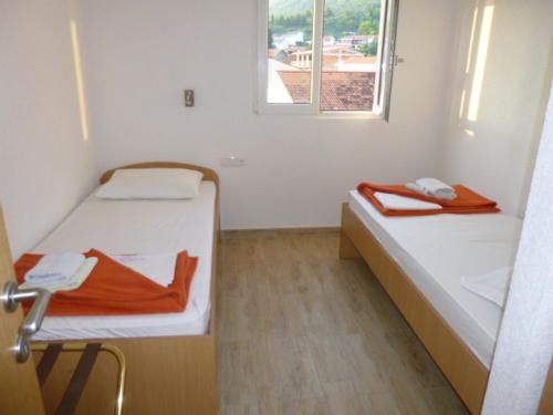 a small room with two beds and a window at Apartments Grozdana in Gradac