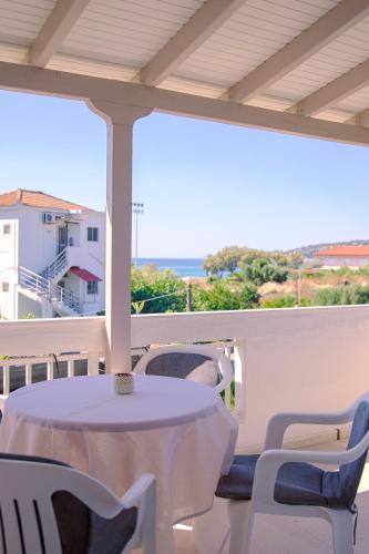 a white table and chairs on a balcony with the ocean at Memi Houses in Koroni
