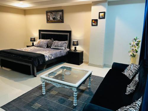 a bedroom with a bed and a coffee table at Entire 1 BR Apartment: Netflix, Youtube. in Islamabad