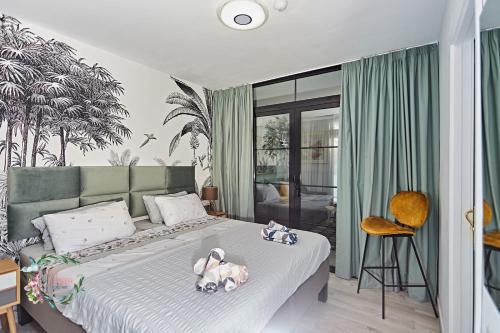 Un dormitorio con una cama con dos perros. en Parrot's House- Yumbo center, en Playa del Inglés