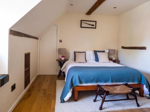 a bedroom with a large bed with a blue blanket at Mallard Cottage in Winchester