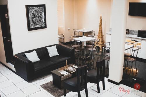 ein Wohnzimmer mit einer schwarzen Couch und einem Tisch in der Unterkunft Hotel Paris in Machala